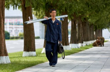 Pyongyang, Kuzey Kore-12 Ekim 2017: Bir Pyongyang sakini sokakta alüminyum bir profil taşıyor