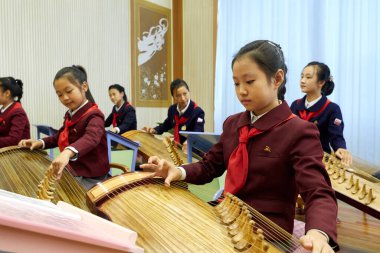Pyongyang, Kuzey Kore - 12 Ekim 2017: Koreli bir kız, Koreli bir müzik enstrümanı olan Kayageum 'u Pioneers and Schoolkids Sarayı' nda çalıyor.