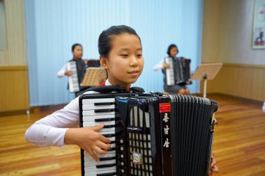 Pyongyang, Kuzey Kore-12 Ekim 2017: Koreli kız Pioneers and Schoolkids Sarayı 'nda akordeon çalıyor