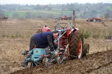 Bir traktör Saban bir alanda çeker.