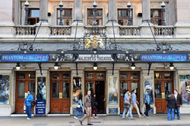 People walk past Her Majesty's Theatre in the West End
