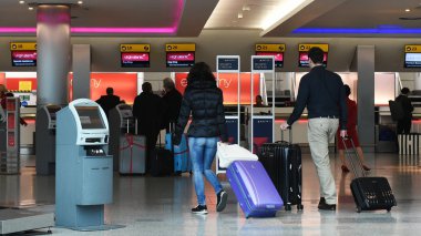 İnsanlar Heathrow havaalanında uçuşlar için iade