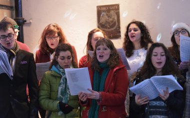 İnsanlar sokaklarda Noel pazarında şarkıları şarkı