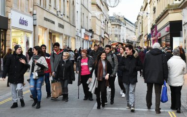 Şehrin alışveriş bölgesinde bir cadde boyunca insanlar yürümek
