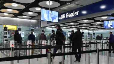 Heathrow Havaalanı'nda gümrük kanallar aracılığıyla uçak yolcuları geçmek.