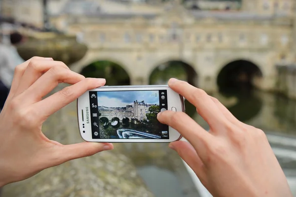 Un turista utiliza un smartphone para capturar el puente Pultney — Foto de Stock