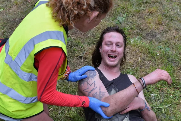 Ein verletzter Nachtschwärmer wird von einem Sanitäter behandelt — Stockfoto