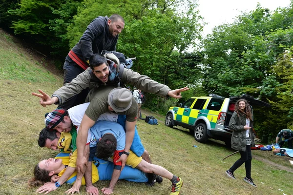 Los juerguistas se amontonan en un competidor en las tradicionales carreras de quesos en Cooper 's Hill — Foto de Stock