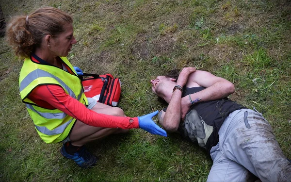 Ein verletzter Nachtschwärmer wird von einem Sanitäter behandelt — Stockfoto