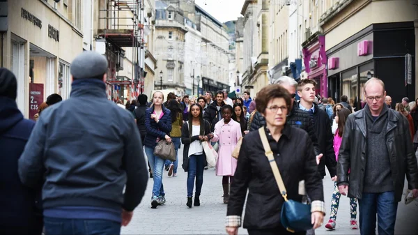 La gente camina por una calle en el distrito comercial de la ciudad — Foto de Stock
