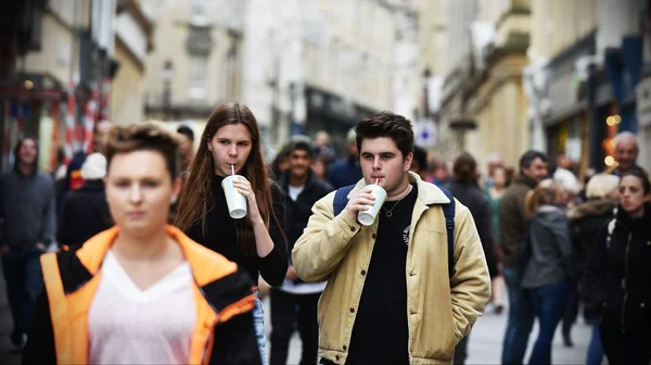 La gente camina por una calle en el distrito comercial de la ciudad — Foto de Stock