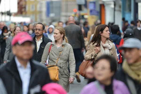 Crowds of people walk along a busy shopping street. — Stock Photo, Image