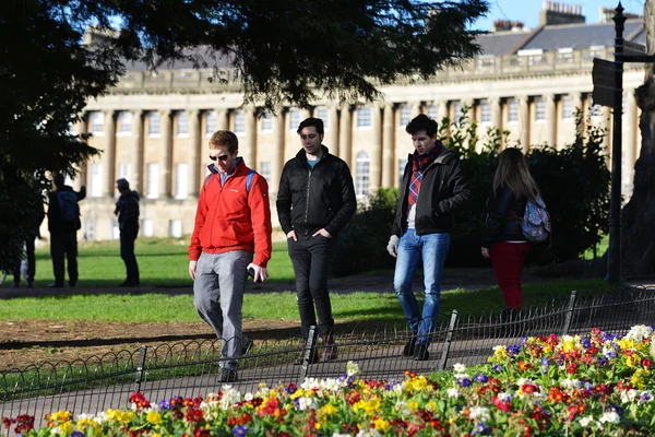 İnsanlar Victoria Park boyunca Royal Crescent Simgesel Yapı altında yürümek..
