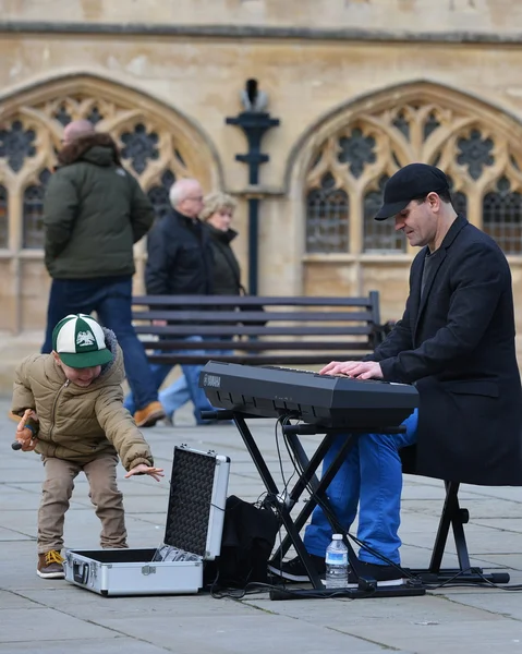 Een Busker speelt piano op de binnenplaats van Bath Abbey — Stockfoto