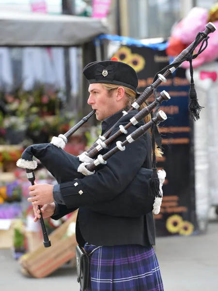 Чоловік в традиційному шотландському вбранні грає на волинки — стокове фото