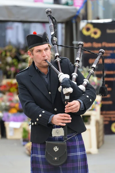 A man in traditional Scottish attire plays bagpipes — Stock Photo, Image