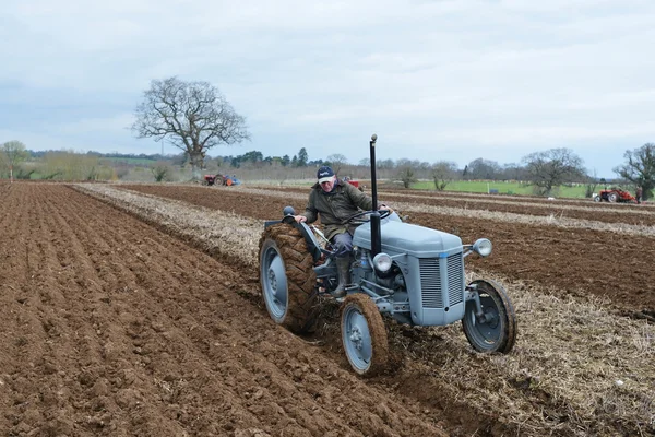 A tractor pulls a plough through a field — Stock Photo, Image