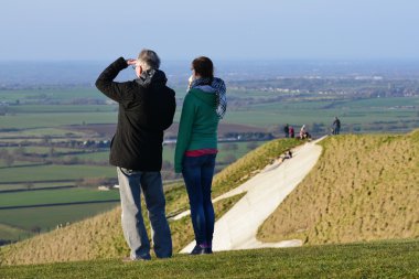 İnsanlar güneşli bir gün Salisbury düz üzerinde Westbury White Horse tadını çıkarın. 