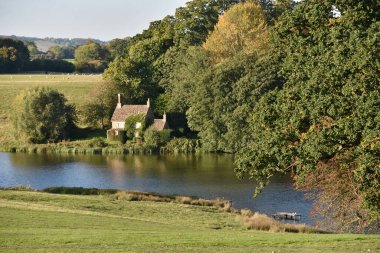 Yeşil Tarlalar ve Güzel Kırsal Bölgedeki Yapraklı Ağaçlarla çevrili Bir Kır Evi Manzarası