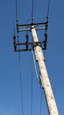 Mavi gökyüzü arka planında yüksek voltaj iletisi