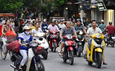 Hanoi, Vietnam - 23 Haziran 2017: Motosikletliler kalabalık bir şehir merkezi caddesi boyunca geziyorlar.