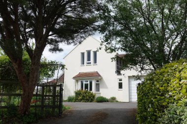 Dış görünüş ve güzel bir evin zemini. Bir İngiliz kasabasındaki bir caddede yapraklı ağaçlarla çerçevelenmiş.