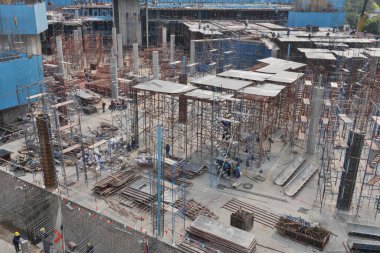 İnşaat işçileri, 22 Aralık 2010 'da Bangkok, Tayland' da büyük bir kentsel kalkınma sahasında karmaşık inşaat ve çelik inşaat inşaat inşaat inşaat inşaat inşaat inşaat demirleri inşa ediyorlar. Manzara, modern metropol genişlemesi için gereken karmaşık altyapıyı vurguluyor.