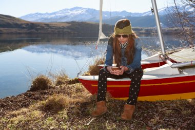 Akıllı telefon kullanan genç bir kadın. 