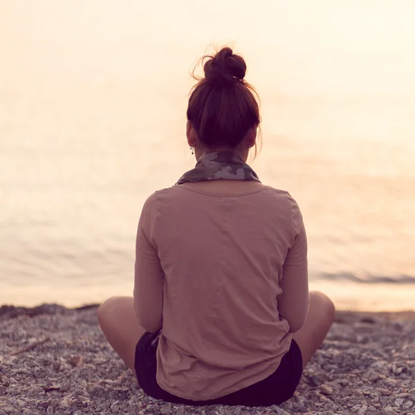 sakin plaj gün batımında meditasyon kadın.