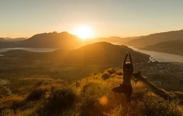 Yoga siluet günbatımında dağda pratik kadın