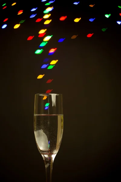 Światła bokeh kształt liści pływających z szampan szkło — Zdjęcie stockowe