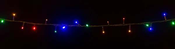 Siyah arka plan üzerine parlak Noel ışıkları — Stok fotoğraf