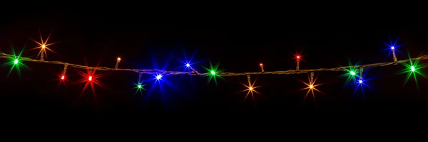 Siyah arka plan üzerine parlak Noel ışıkları — Stok fotoğraf