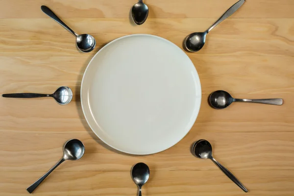 Placa blanca rodeada de cucharas —  Fotos de Stock