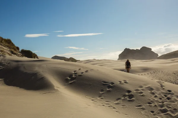Woman traveler walking on sand dune