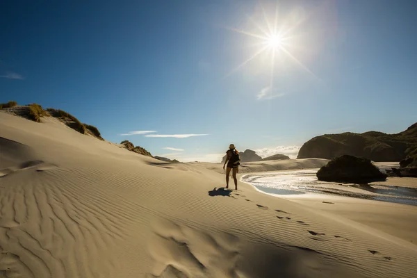 Woman traveler walking on sand dune — Stock Photo, Image