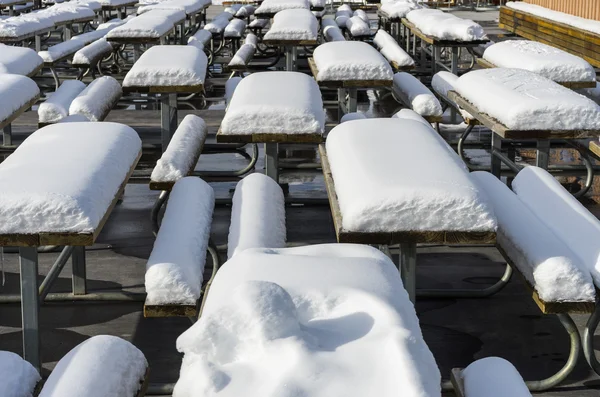 Mesas e cadeiras cobertas de neve Fotos De Bancos De Imagens