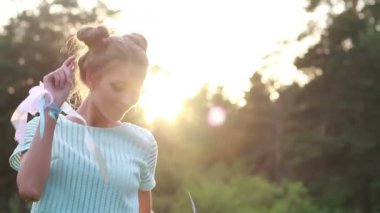 Parkta dans kızları. Güneş parlak parlama. Şirin kız parkta yürüyüş. Yeşil orman. Parlak gün batımı.