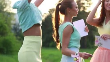 Parkta dans kızları. Güneş parlak parlama. Şirin kız parkta yürüyüş. Yeşil orman. Parlak gün batımı.