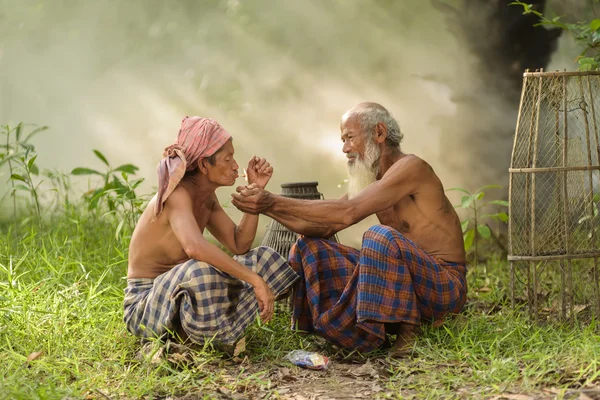 Old man helps to  lighting a cigarette for another — Stock Photo, Image