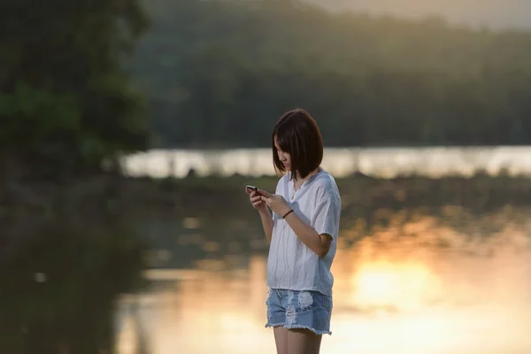 Mujer joven mensajes de texto en el teléfono inteligente — Foto de Stock