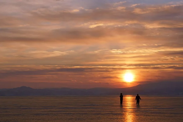 Двое мужчин идут по солнечной тропе на закате — стоковое фото