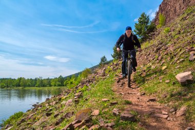 Irkut Nehri yakınında kayalık yol boyunca bisikletçi rides