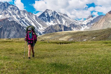 tunka aralıktaki Alpin çayırlar üzerinde yürüyen turist