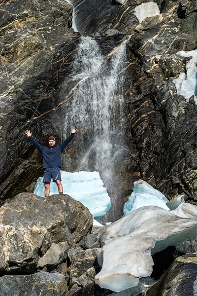Turista de pé ao lado de uma cachoeira — Fotografia de Stock