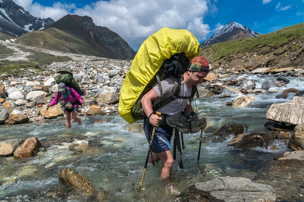 Two tourists crossing the mountainous river Ekhe-Ger — Stock Photo, Image