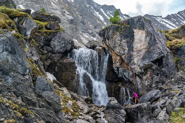 Flicka samlar vatten i ett vattenfall — Stockfoto