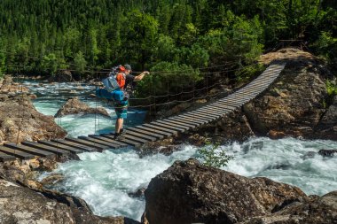 Turist asma köprü üzerinde Selenginka Nehri üzerinde geçer.