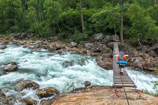 Touristen passieren die Hängebrücke über die Selenginka — Stockfoto