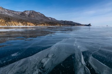 Peschanaya Körfezi manzarası ve Baykal buzunun yüzeyindeki çatlaklar